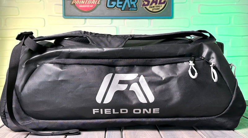 The Field One AW Gear Backpack. The backpack is all black with the Field One logo in grey on the side panel.