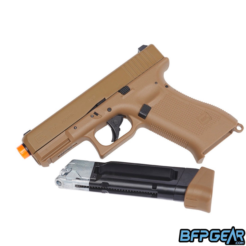 The Glock G19X CO2 Airsoft pistol in the Coyote color. The magazine is removed and shows that it takes a CO2 cartridge.