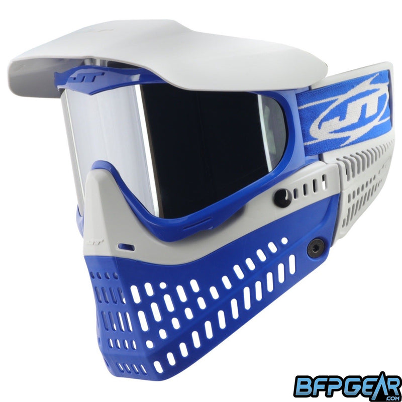 The JT ProFlex Cobalt goggle. Blue flex skirt, blue frame, light grey ears, light grey visor, and light grey faceplate. Installed is the chrome lens. This photo faces the goggle to the left.