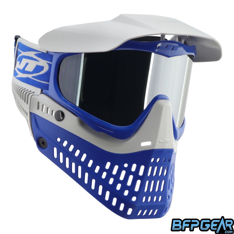 The JT ProFlex Cobalt goggle. Blue flex skirt, blue frame, light grey ears, light grey visor, and light grey faceplate. Installed is the chrome lens. This photo faces the goggle to the right.