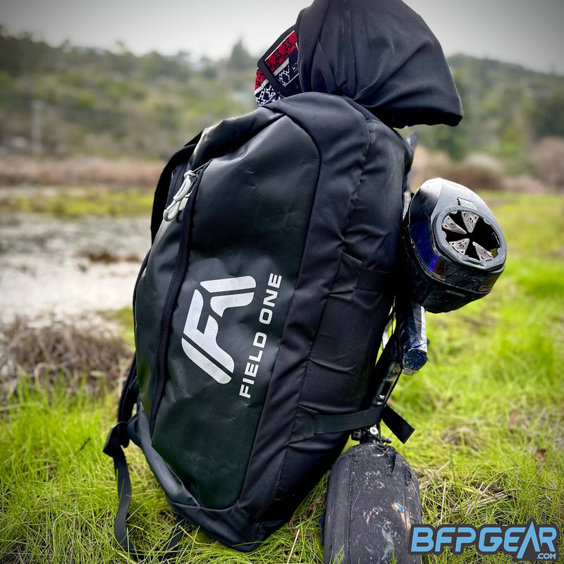 A picture showing the AW backpack filled with paintball equipment. A paintball marker is strapped securely to the side of the backpack, and a paintball goggle is secured to the top of the backpack.