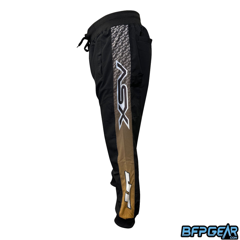 Side view of the XSV 22 Joggers. From the bottom to the top, JT Logo over a gold color, fades to black with the XSV logo over a JT pattern.